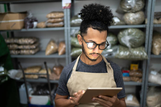 Men using digital tablet in storage room of a natural product shop